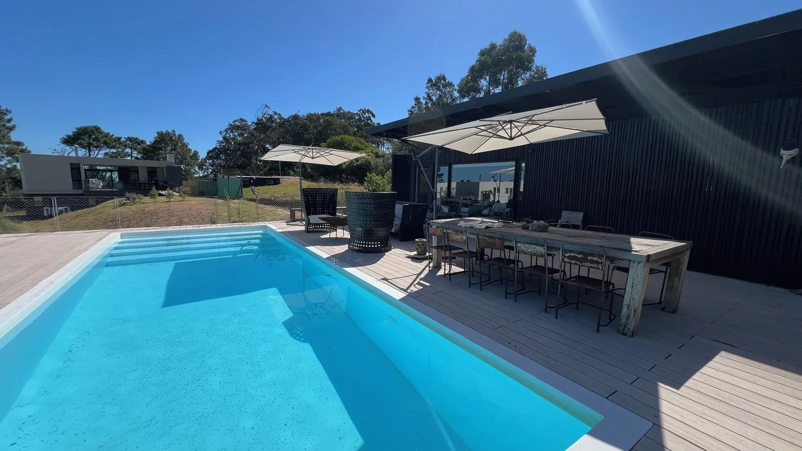 Piscina y terraza con sombrillas abiertas de Kalu Nivasayi